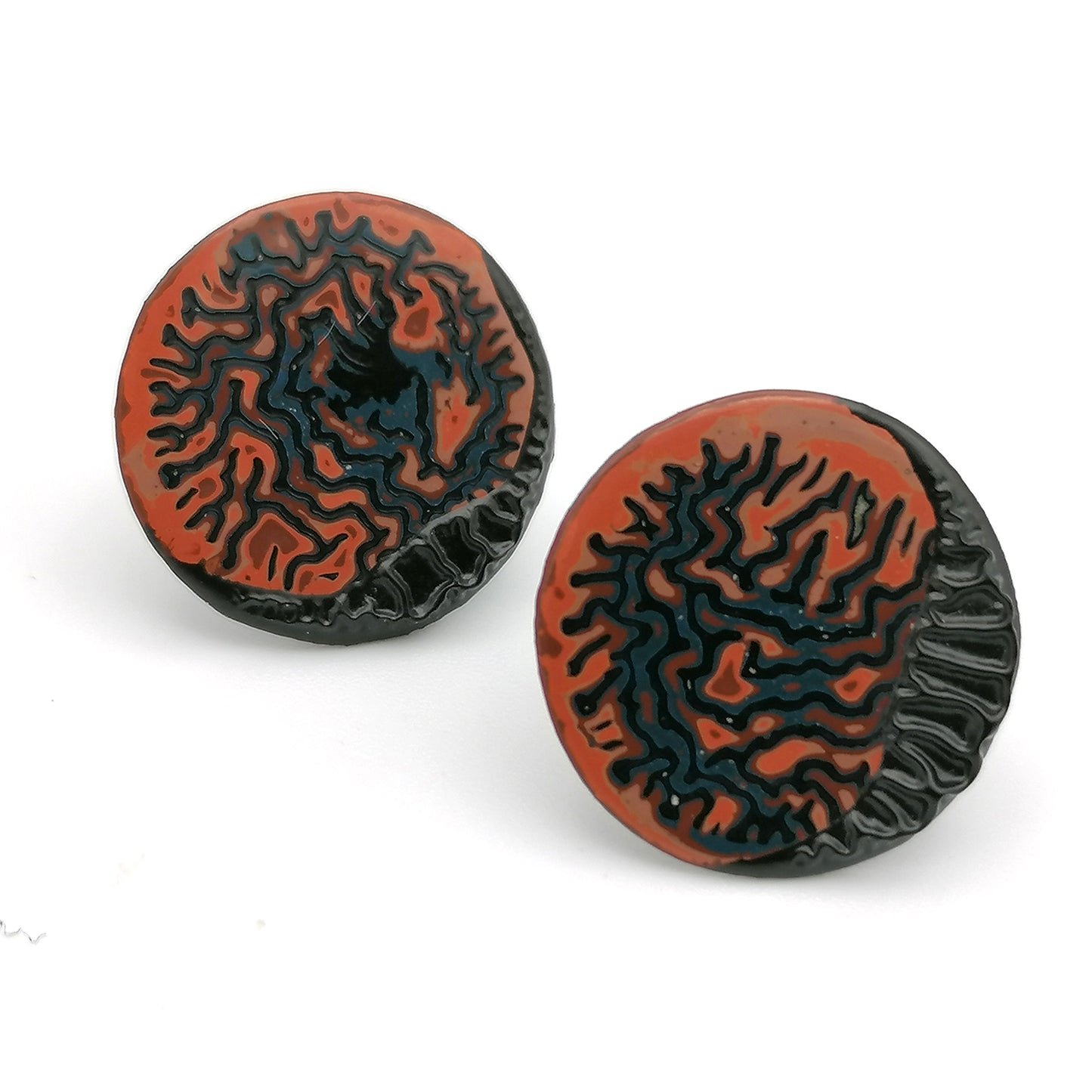 Image shows a pair of circle stud earrings on a white background. With a wrinkled pattern in orange, blue and red and a raised black winkle textured rim.